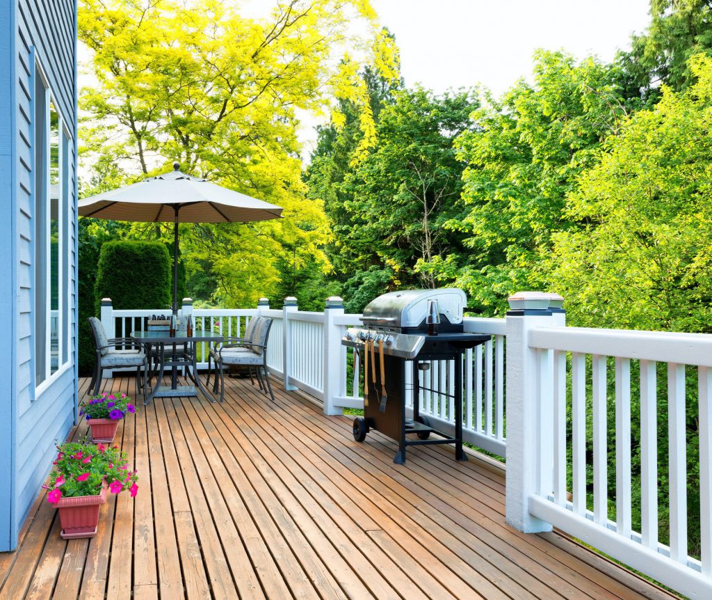 Applying deck stain along the wood grain