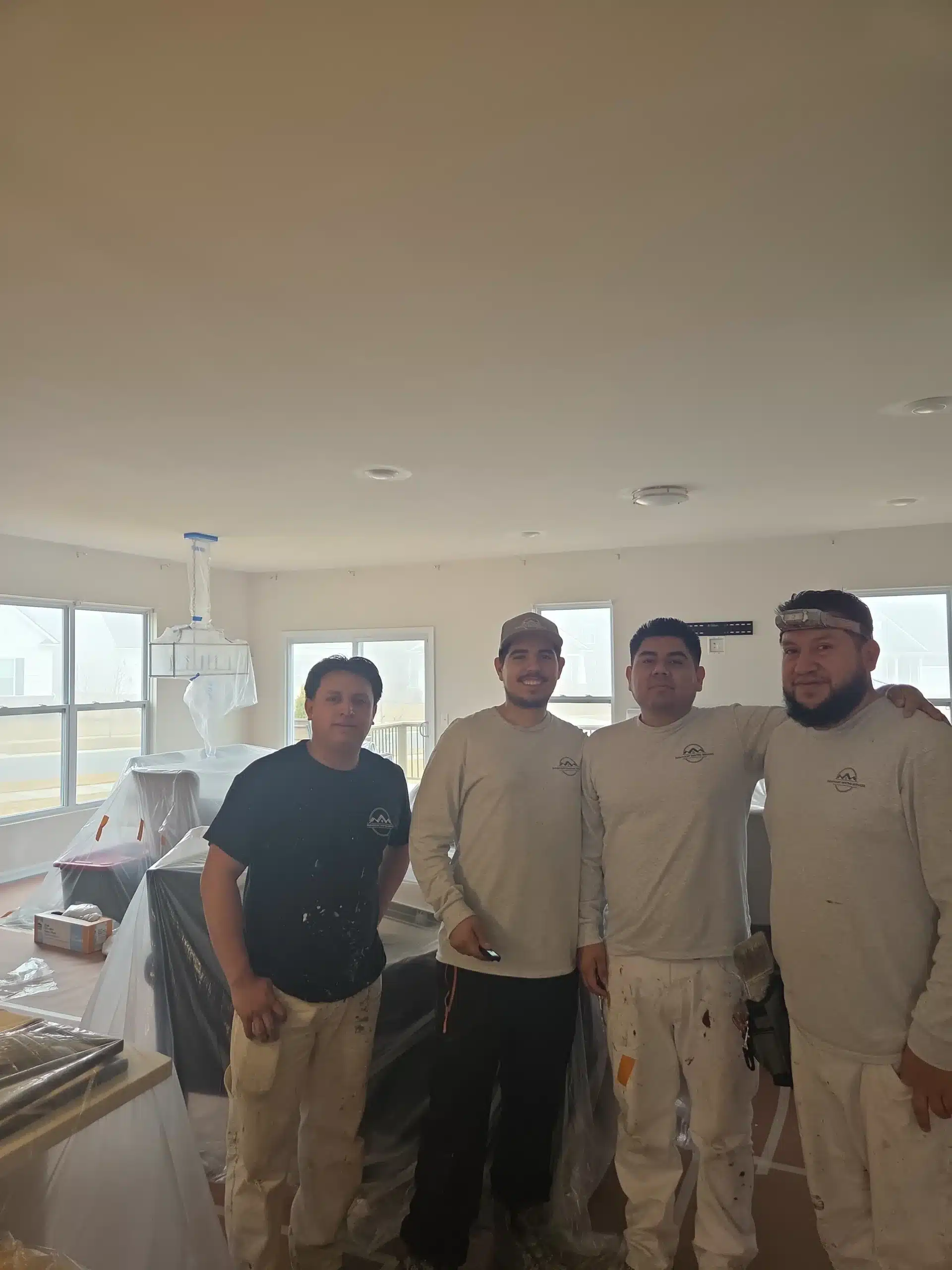 Professional Residential Interior Painting Crew A team of four professional male painters posing in a kitchen prepped for interior painting.